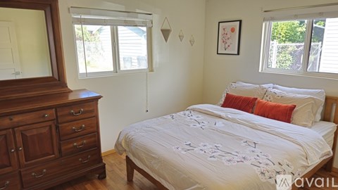 A bedroom with a bed, dresser, and window.