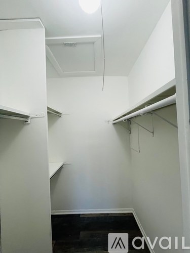 A white kitchen with a cabinet and a shelf.