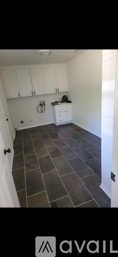 A kitchen with white cabinets and a dark floor.