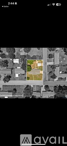 A satellite image of a house surrounded by trees.