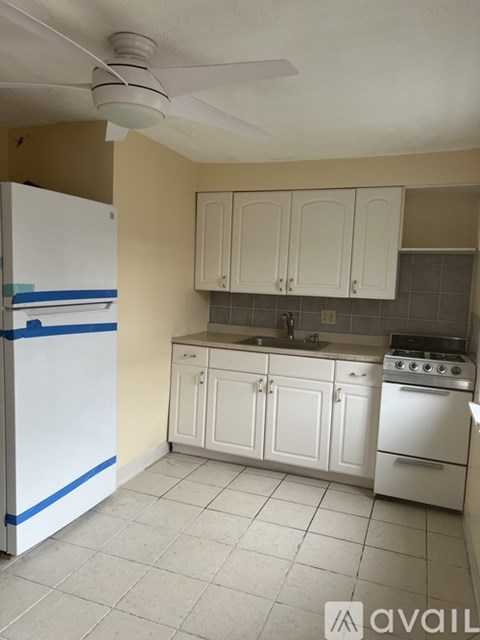 A kitchen with white appliances and cabinets.