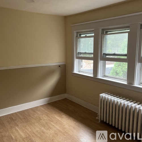 A room with a window and a radiator on the floor.