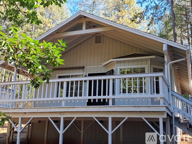 A wooden house with a balcony and a deck.