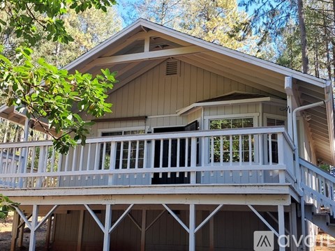 A wooden house with a balcony and a deck.