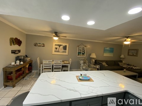 A living room with a white marble table in the foreground.