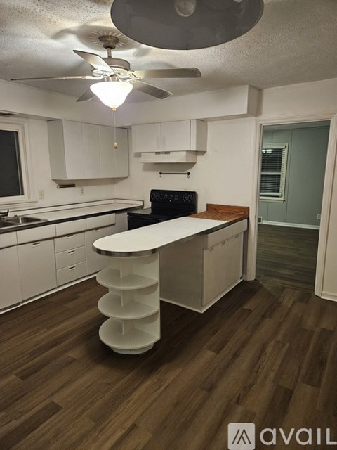 A kitchen with a white counter and a ceiling fan.