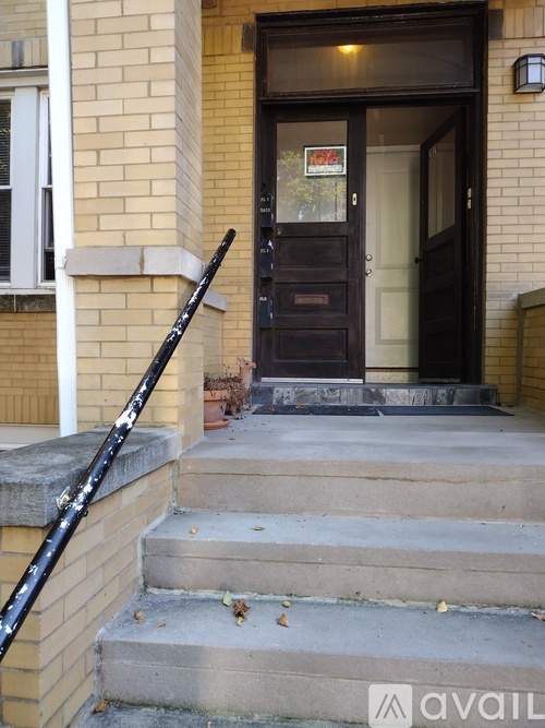 A black door with a glass window and a sign on it.