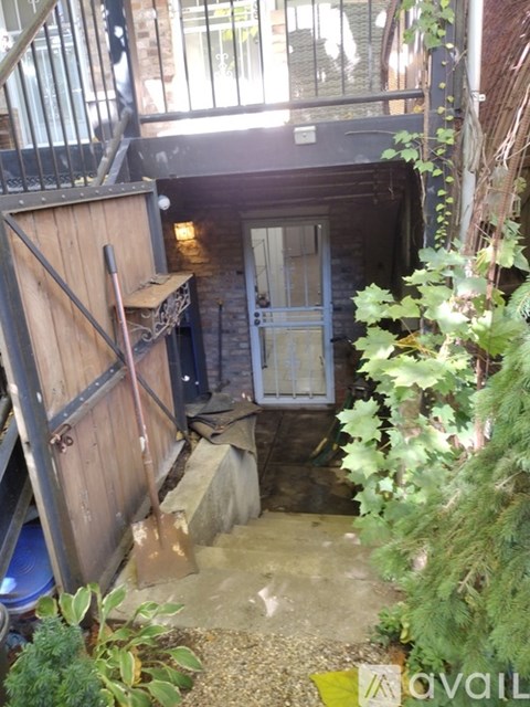 A wooden gate is open to a dark alley.