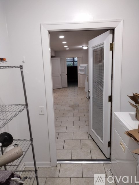 A room with a tiled floor and a doorway leading to another room.