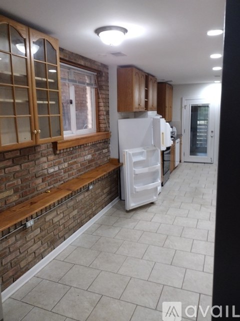 A kitchen with a white fridge and wooden cabinets.