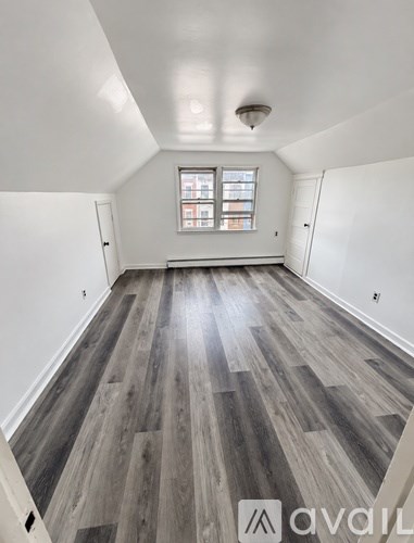 A room with wooden flooring and a window.