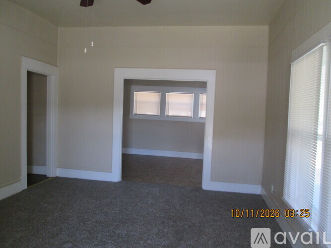 A room with a window and a carpeted floor.