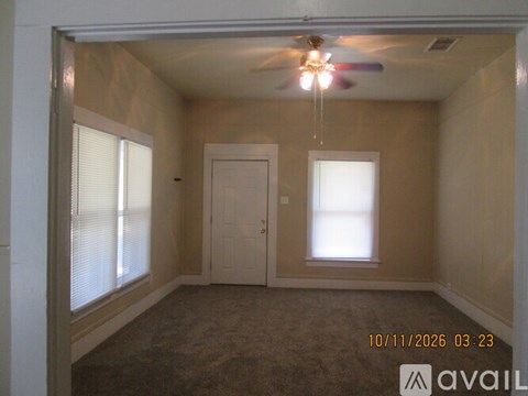 A room with a ceiling fan and a window with blinds.