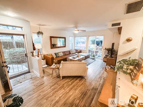 A living room with a striped couch and a wooden floor.