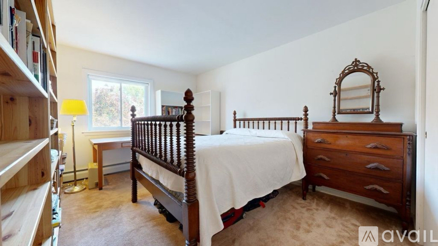 A bedroom with a bed, dresser, and a mirror.