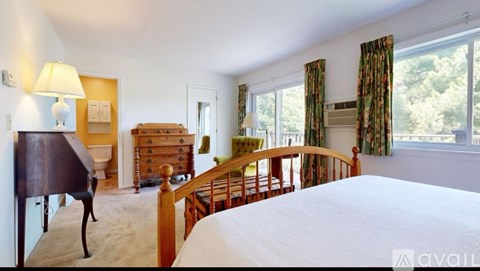 A bedroom with a bed, dresser, and chair.
