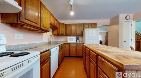 A kitchen with wooden cabinets and a white stove top oven.