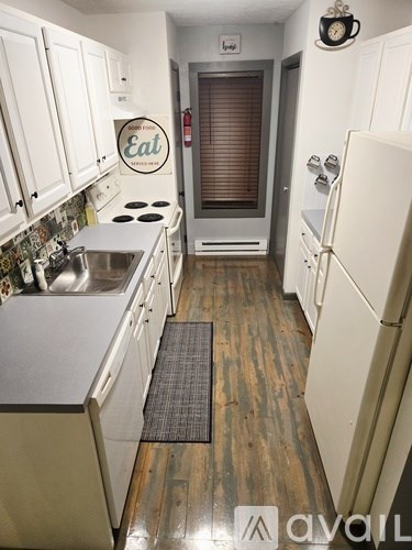 A kitchen with white cabinets and a sign that says eat.