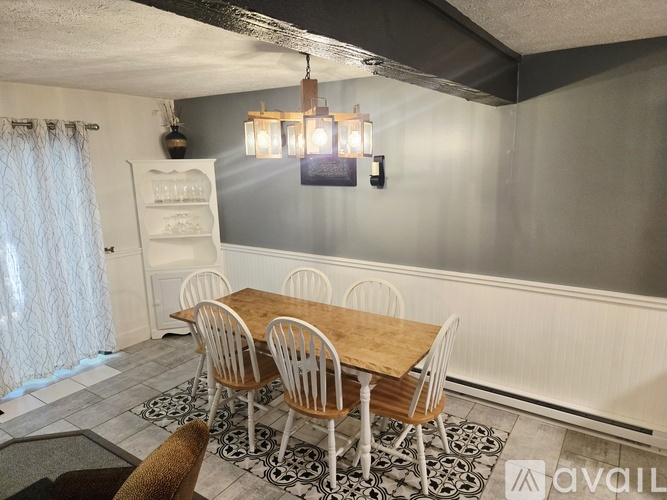 A dining room with a wooden table and chairs.