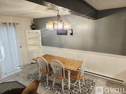 A dining room with a wooden table and chairs.