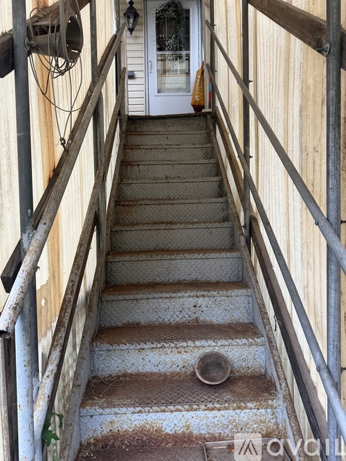A staircase with a metal railing and a door at the end.