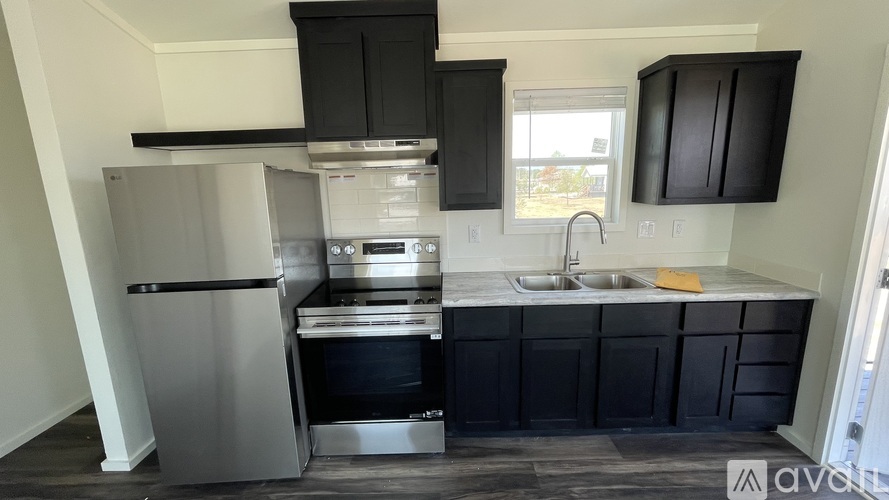 A kitchen with black cabinets and stainless steel appliances.