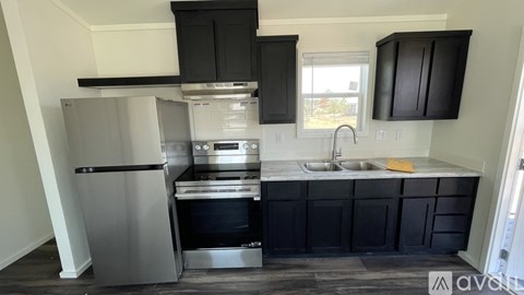 A kitchen with black cabinets and stainless steel appliances.