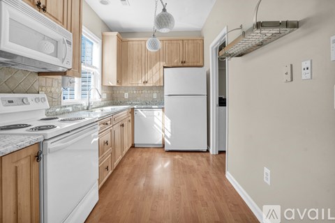 A kitchen with white appliances and wooden cabinets.