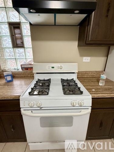 A white gas stove with four burners is in a kitchen.