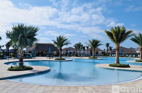 A large pool surrounded by palm trees and a clear blue sky.