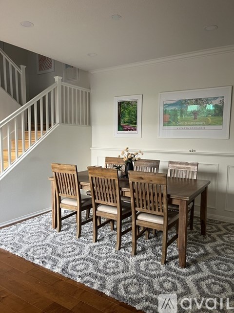 A dining room with a table and chairs.