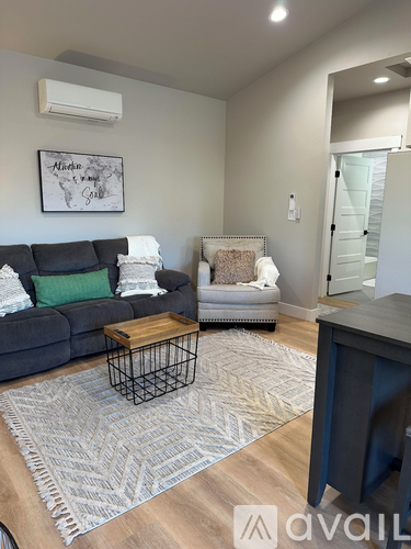 A living room with a grey couch and a coffee table.