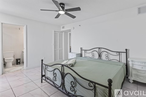 A bedroom with a bed, dresser, and toilet visible.