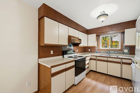 A kitchen with wooden cabinets and a stove top oven.