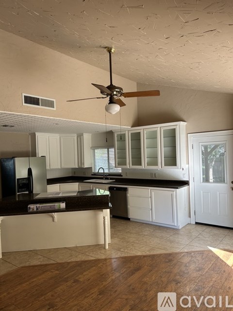 A kitchen with white cabinets and a wooden floor.