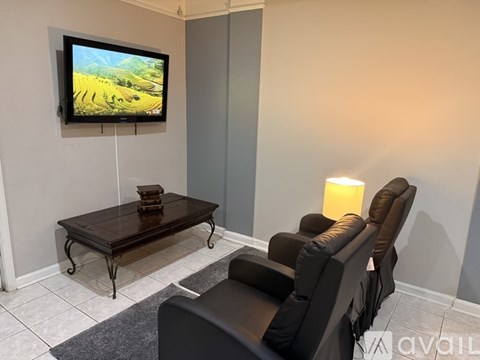 A living room with a television, a table, and chairs.
