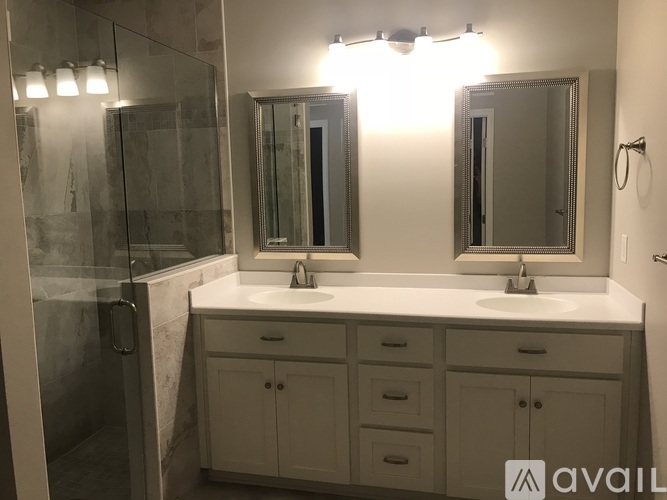 A bathroom with a white countertop and a large mirror above it.