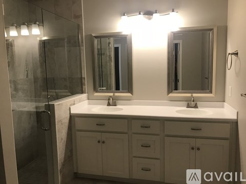 A bathroom with a white countertop and a large mirror above it.