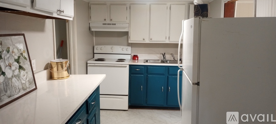 A kitchen with a white fridge and blue cabinets.