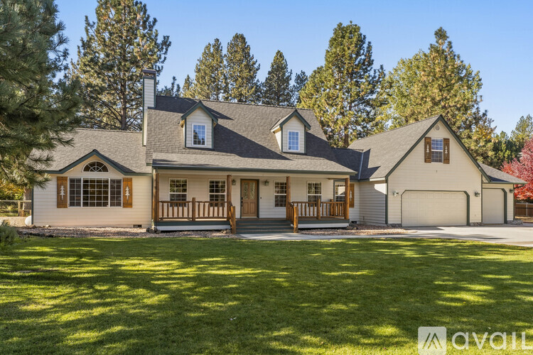 A house with a front yard and trees in the background.