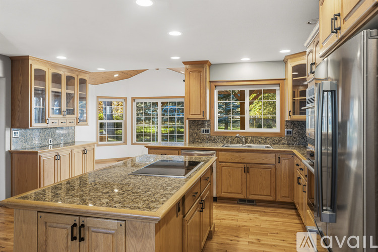 A kitchen with wooden cabinets and granite countertops.