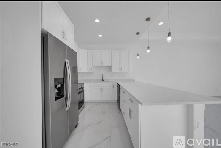A modern kitchen with a refrigerator, cabinets, and a countertop.