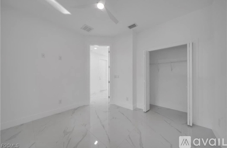 A spacious room with marble flooring and white walls.
