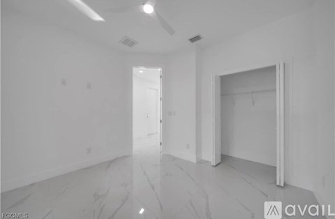 A spacious room with marble flooring and white walls.