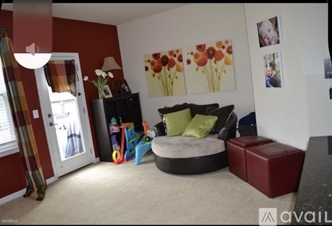 A living room with a red wall and a grey couch.