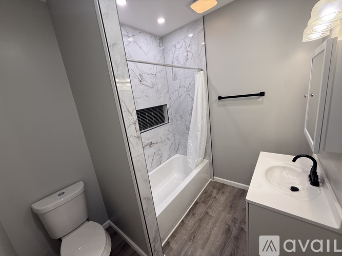 A bathroom with a toilet, sink, and a walk-in shower.