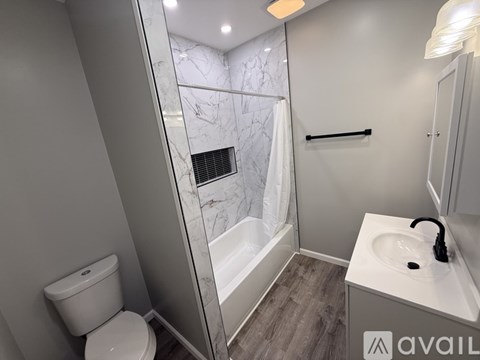 A bathroom with a toilet, sink, and a walk-in shower.