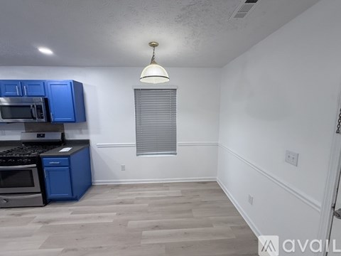 A kitchen with blue cabinets and a microwave.