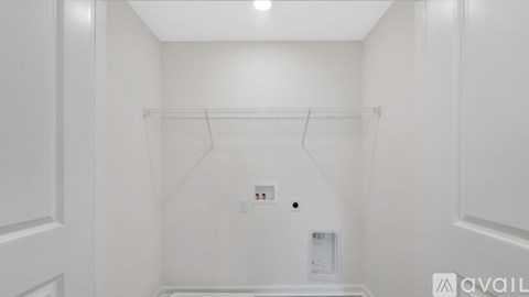 A white closet with a hanger and a white door.