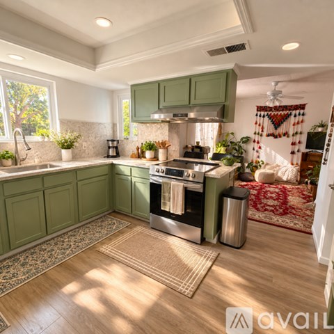 A kitchen with green cabinets and a stainless steel oven.